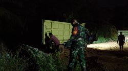 Hingga Malam Hari, Anggota Satgas TMMD ke 128 Kodim 0420/Sarko Tetap Bekerja Turunkan Material Batu di Lokasi Perbaikan Jalan 