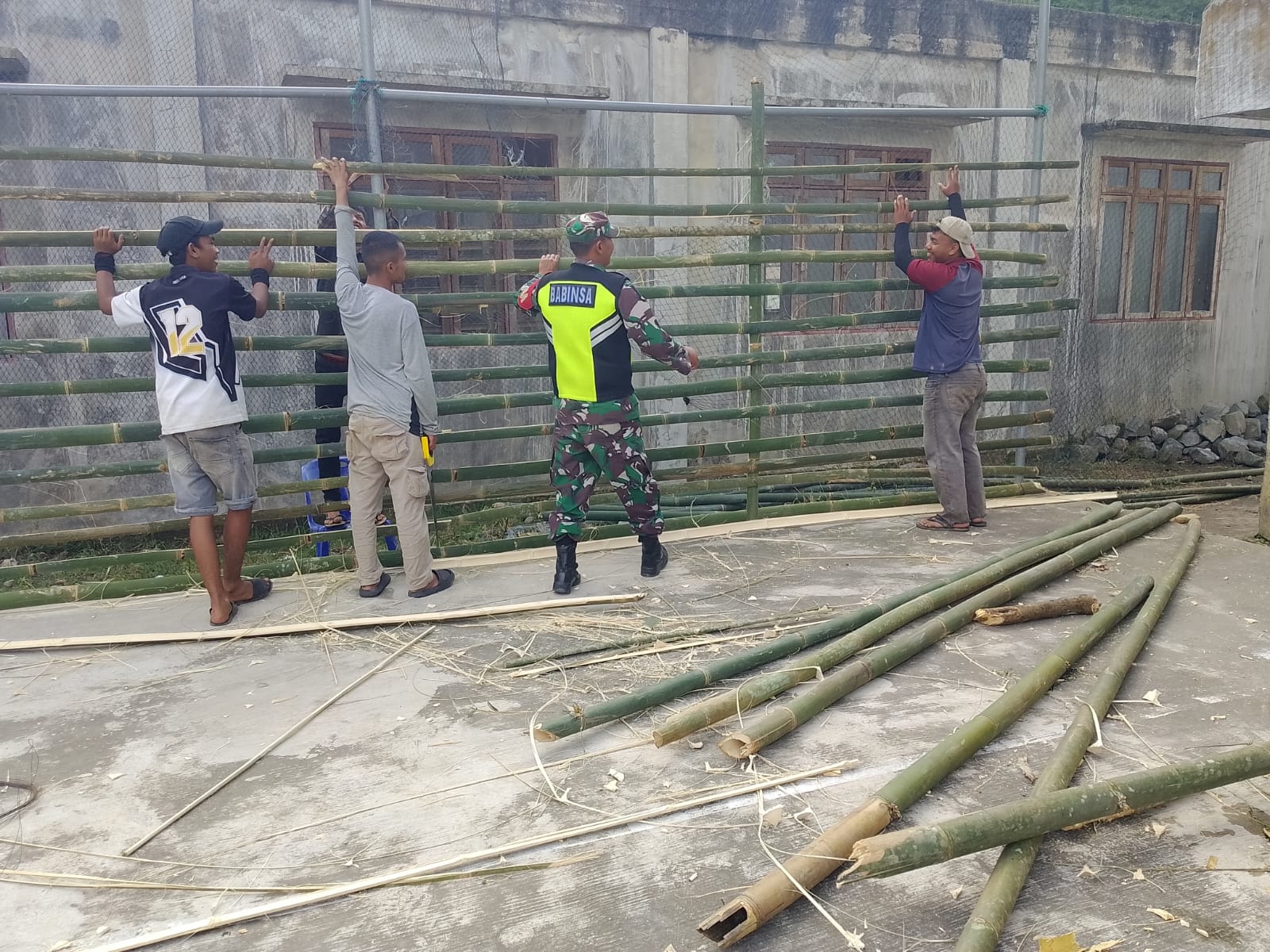 Babinsa Koramil 04/Bintang Bantu Warga Bangun Pagar Lapangan Voli di Desa Wilah Setie