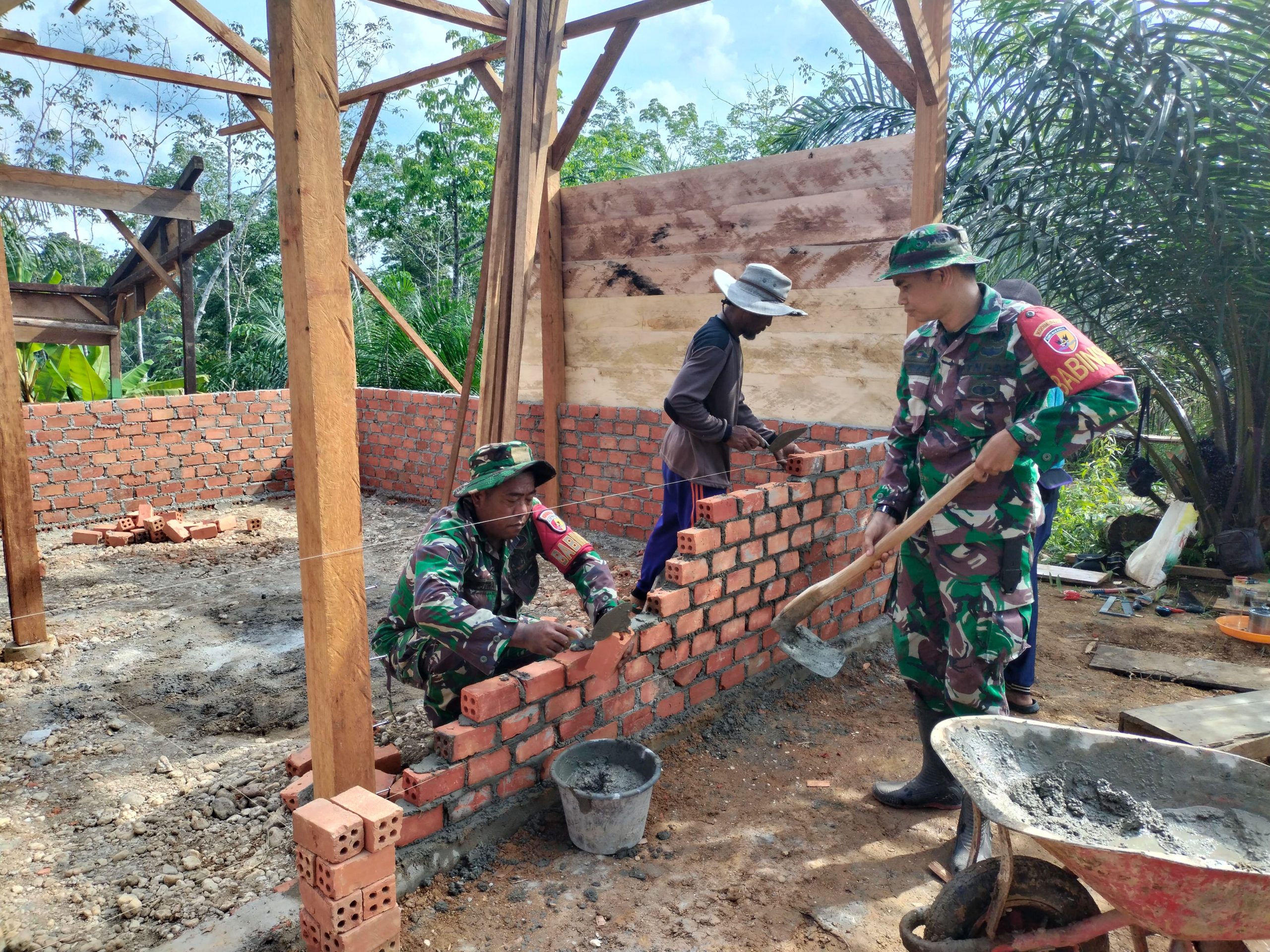 Anggota Satgas TMMD Ke-128 Kodim 0420/Sarko Pasang Dinding Bata Rumah Layak Huni Milik Lukman 