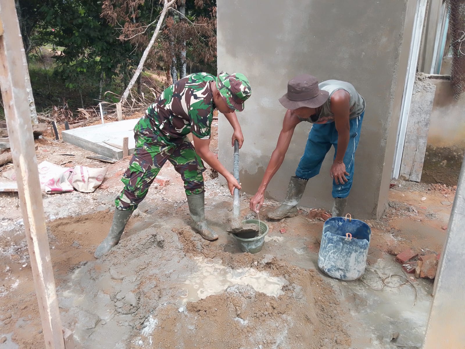 Semangat Gotong Royong, Kopda Bambang Gunawan Bersama Warga Siapkan Adukan Semen untuk Plaster MCK Masjid Nurul Huda