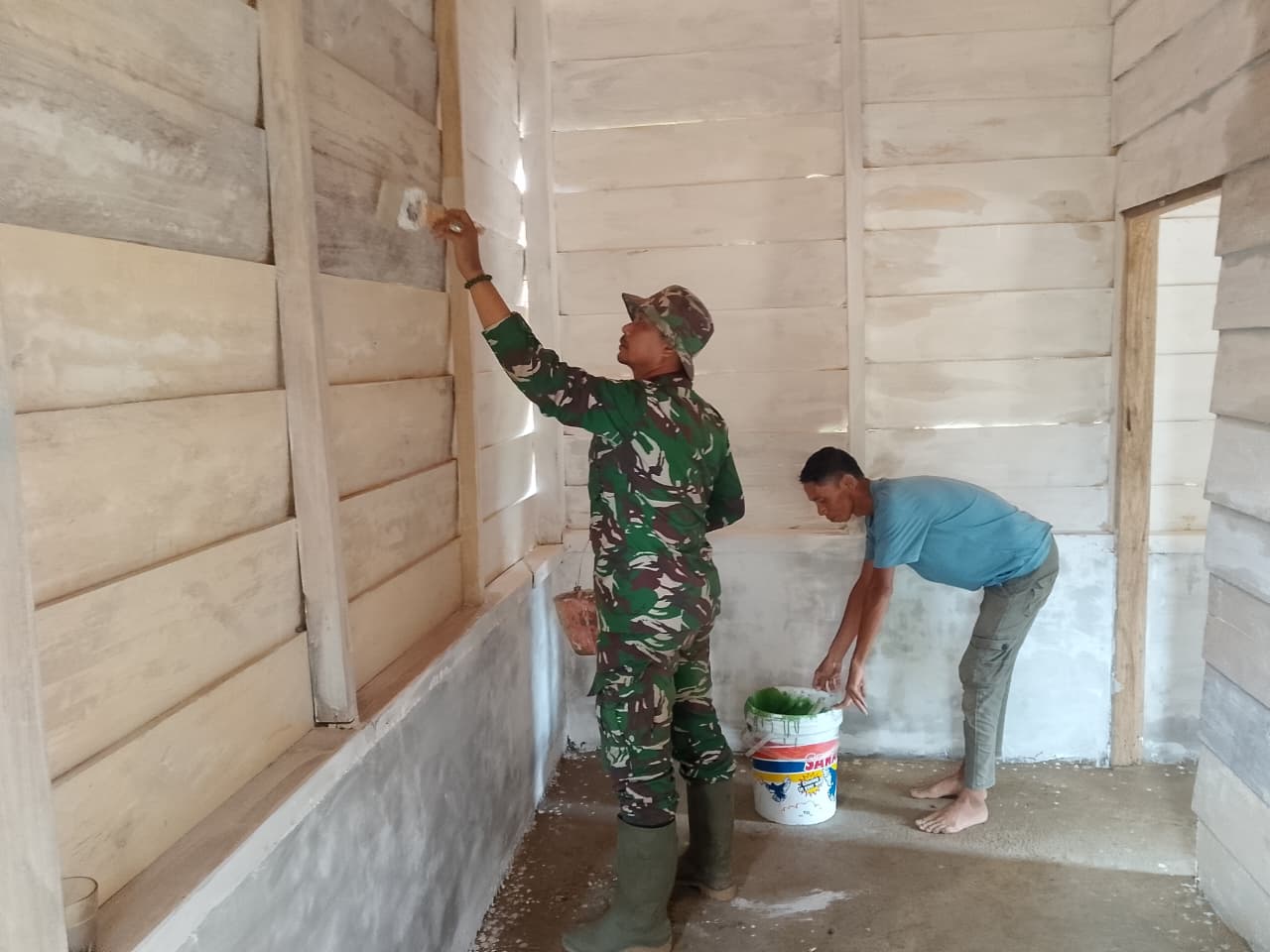 Wujud Kepedulian Satgas TMMD Terhadap Keindahan, Kopda Ismail Bersama Bapak Kiki Laksanakan Pengecatan Ruangan 